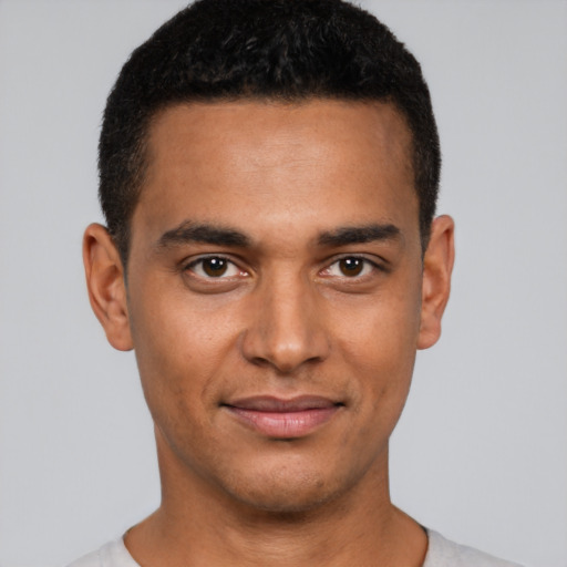 Joyful latino young-adult male with short  brown hair and brown eyes