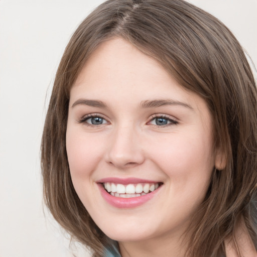 Joyful white young-adult female with medium  brown hair and green eyes