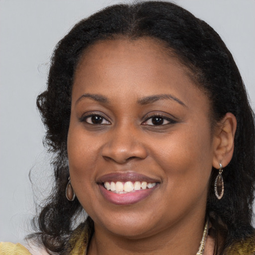 Joyful black young-adult female with long  brown hair and brown eyes