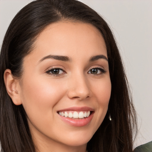 Joyful white young-adult female with long  brown hair and brown eyes