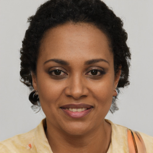 Joyful black adult female with short  brown hair and brown eyes