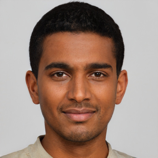 Joyful black young-adult male with short  black hair and brown eyes