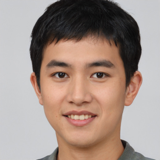 Joyful asian young-adult male with short  black hair and brown eyes
