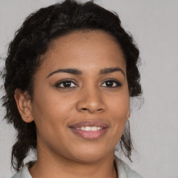 Joyful black young-adult female with long  brown hair and brown eyes