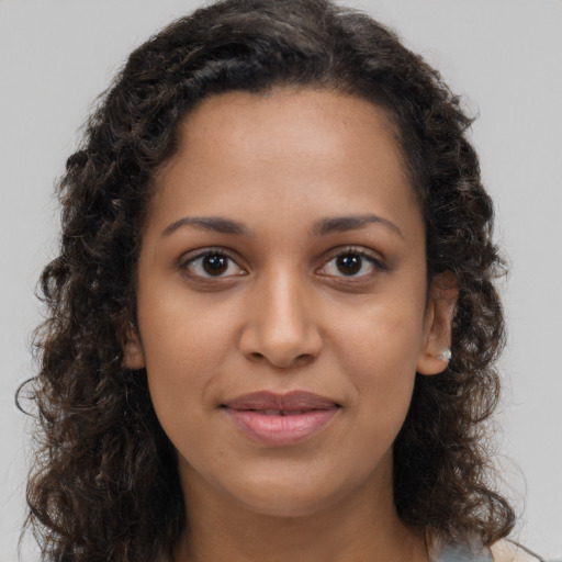 Joyful black young-adult female with long  brown hair and brown eyes