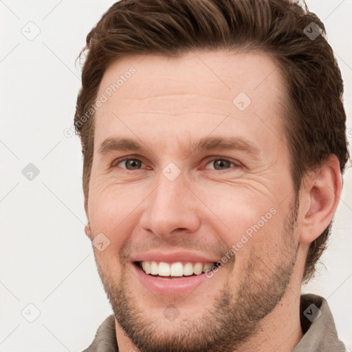 Joyful white young-adult male with short  brown hair and grey eyes