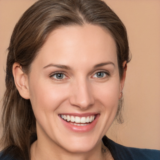 Joyful white young-adult female with medium  brown hair and grey eyes