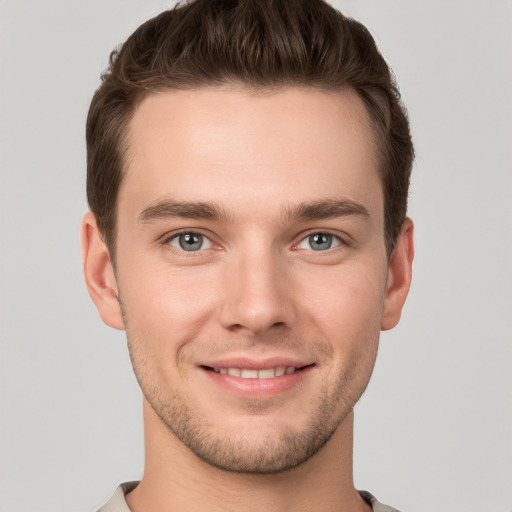 Joyful white young-adult male with short  brown hair and grey eyes