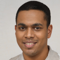 Joyful latino young-adult male with short  black hair and brown eyes