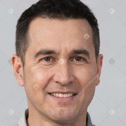 Joyful white adult male with short  brown hair and brown eyes