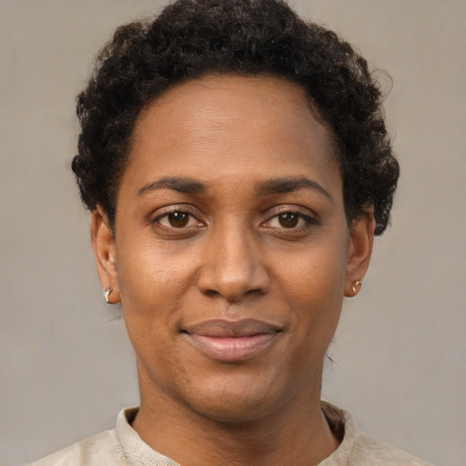 Joyful black young-adult female with short  black hair and brown eyes