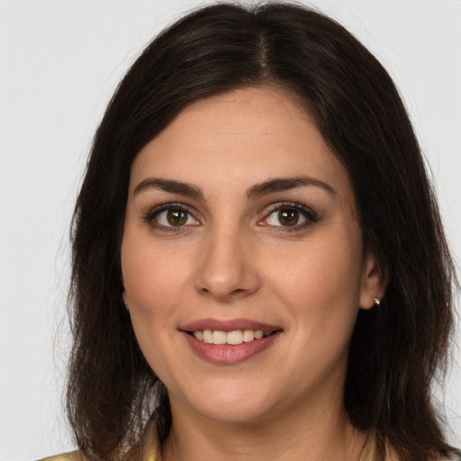 Joyful white young-adult female with long  brown hair and brown eyes