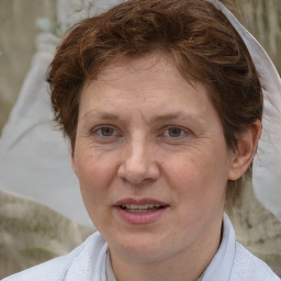 Joyful white adult female with short  brown hair and blue eyes