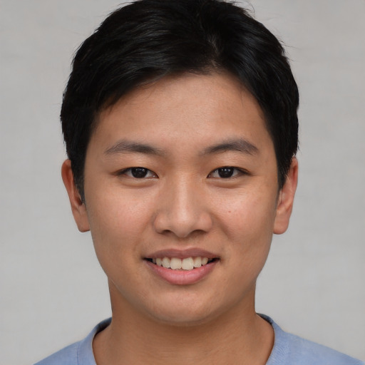 Joyful asian young-adult male with short  black hair and brown eyes