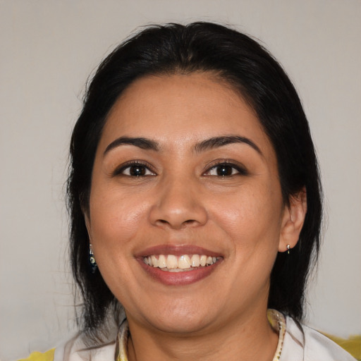 Joyful latino young-adult female with medium  brown hair and brown eyes