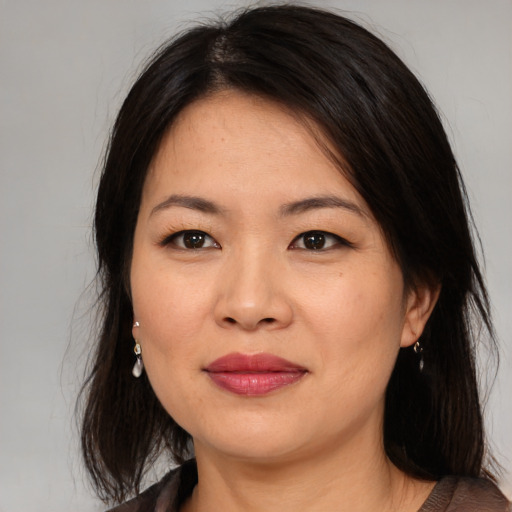 Joyful asian young-adult female with medium  brown hair and brown eyes
