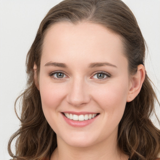 Joyful white young-adult female with long  brown hair and grey eyes