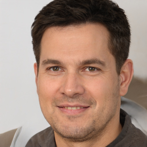 Joyful white adult male with short  brown hair and brown eyes