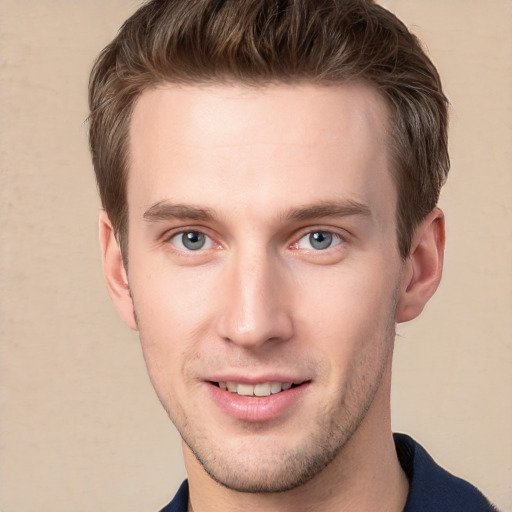 Joyful white young-adult male with short  brown hair and grey eyes