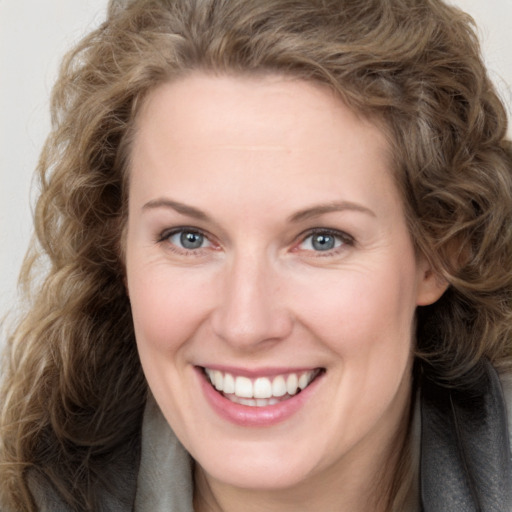 Joyful white adult female with long  brown hair and brown eyes