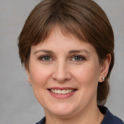 Joyful white young-adult female with medium  brown hair and grey eyes