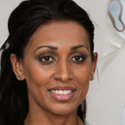 Joyful black young-adult female with long  brown hair and brown eyes