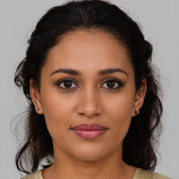 Joyful latino young-adult female with medium  brown hair and brown eyes