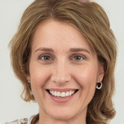 Joyful white young-adult female with medium  brown hair and green eyes