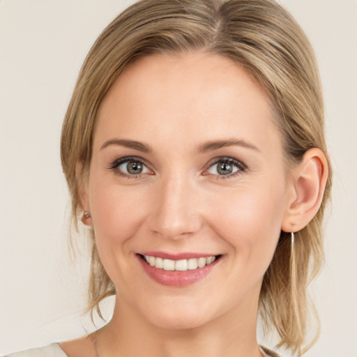 Joyful white young-adult female with medium  brown hair and blue eyes