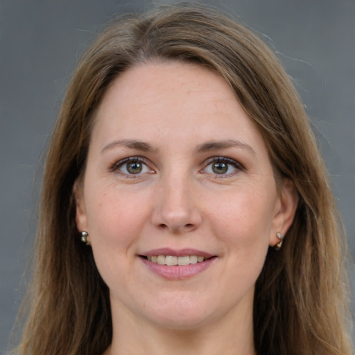 Joyful white adult female with long  brown hair and grey eyes