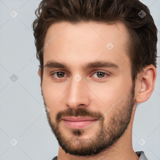 Joyful white young-adult male with short  brown hair and brown eyes