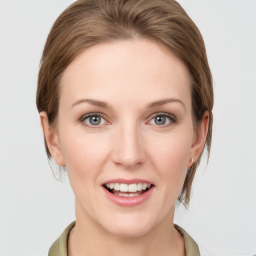 Joyful white young-adult female with medium  brown hair and grey eyes