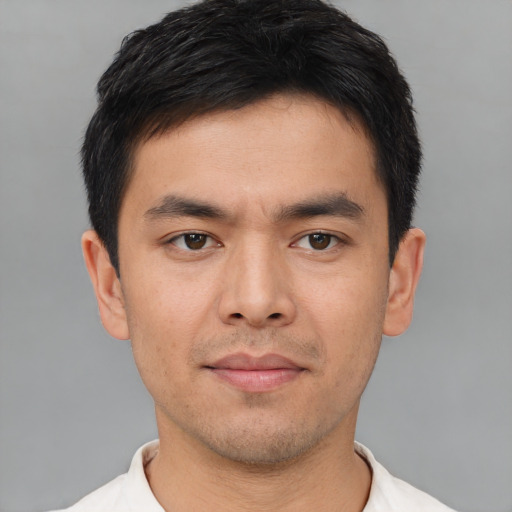 Joyful asian young-adult male with short  brown hair and brown eyes