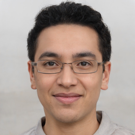 Joyful latino young-adult male with short  brown hair and brown eyes