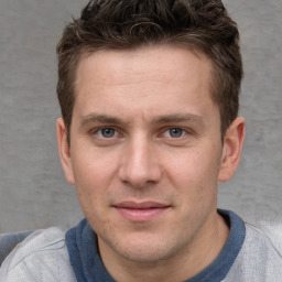 Joyful white young-adult male with short  brown hair and grey eyes