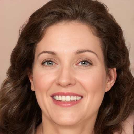 Joyful white adult female with medium  brown hair and green eyes