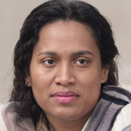 Joyful latino adult female with medium  brown hair and brown eyes