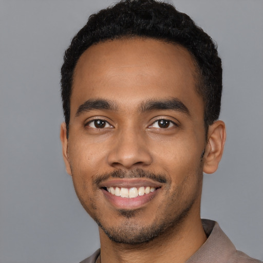 Joyful latino young-adult male with short  black hair and brown eyes
