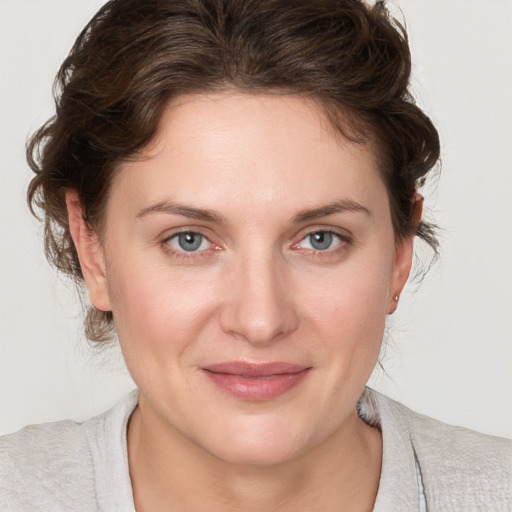 Joyful white young-adult female with medium  brown hair and blue eyes