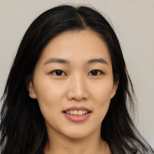 Joyful asian young-adult female with long  black hair and brown eyes