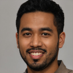Joyful latino young-adult male with short  black hair and brown eyes