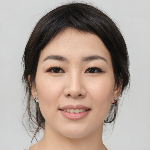Joyful asian young-adult female with medium  brown hair and brown eyes