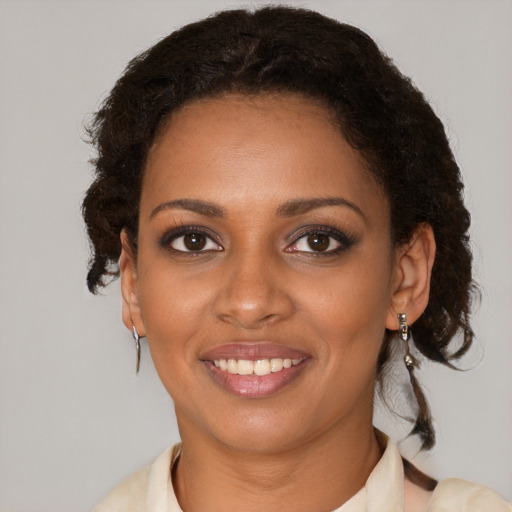 Joyful black young-adult female with short  brown hair and brown eyes