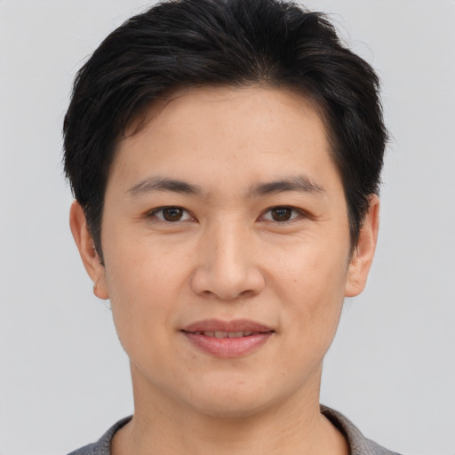 Joyful asian young-adult male with short  brown hair and brown eyes