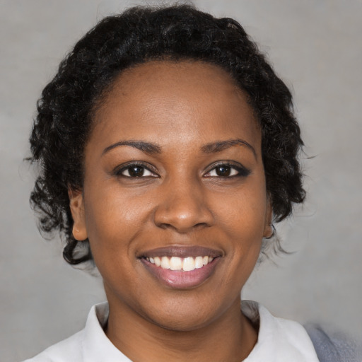 Joyful black young-adult female with medium  brown hair and brown eyes
