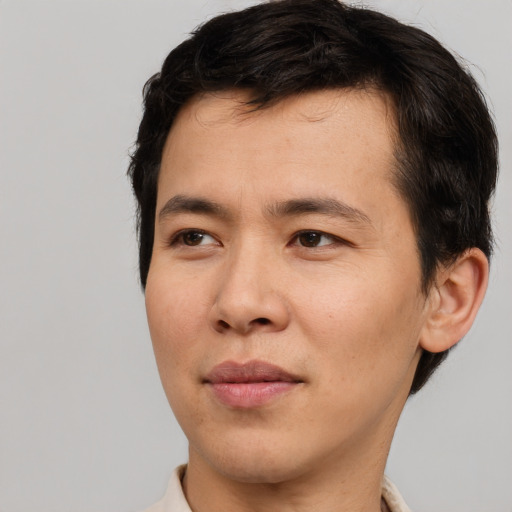 Joyful asian young-adult male with short  brown hair and brown eyes
