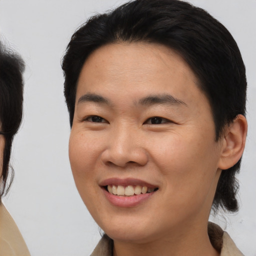 Joyful asian young-adult female with short  brown hair and brown eyes