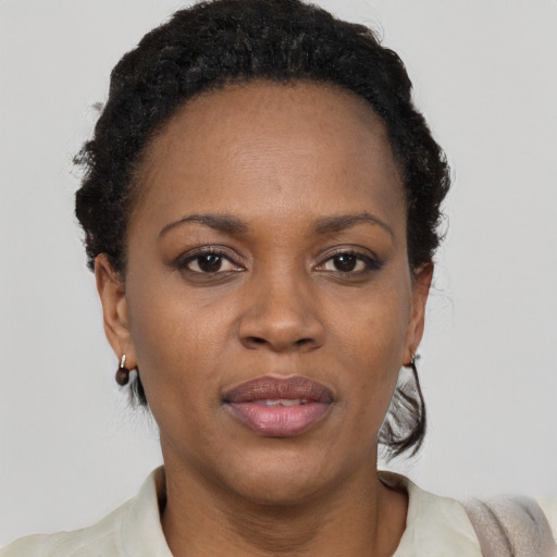 Joyful black adult female with short  black hair and brown eyes