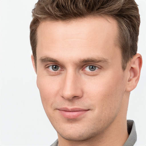 Joyful white young-adult male with short  brown hair and grey eyes