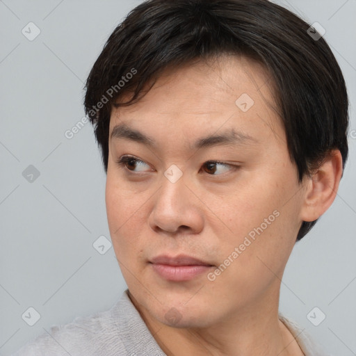 Joyful asian young-adult male with short  brown hair and brown eyes